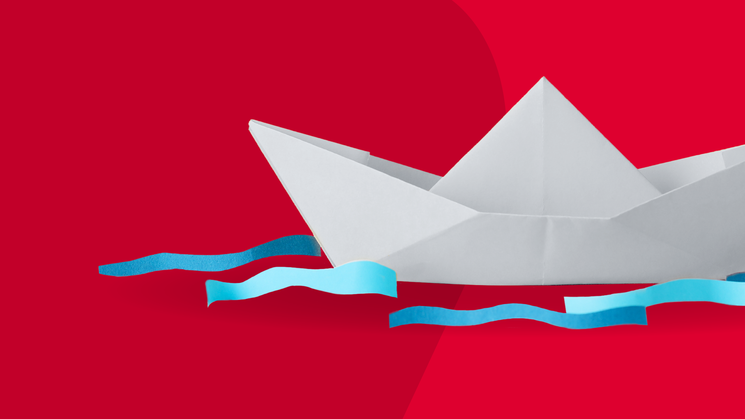 white paper boat on red background