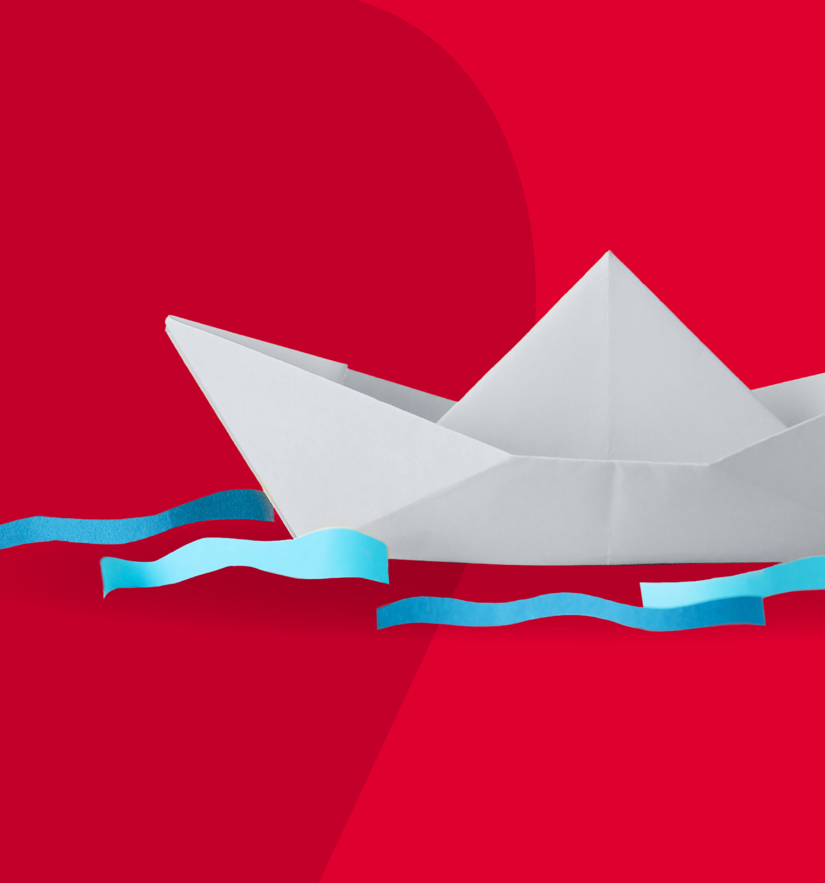 white paper boat on red background