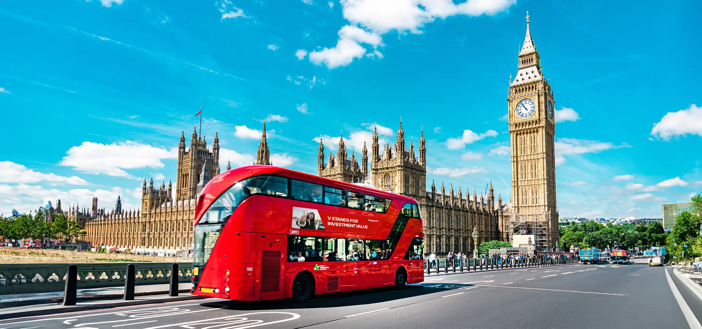 An image of an iconic red double decker bus passing by the 16-story Big Ben clocktower in London, United Kingdom.